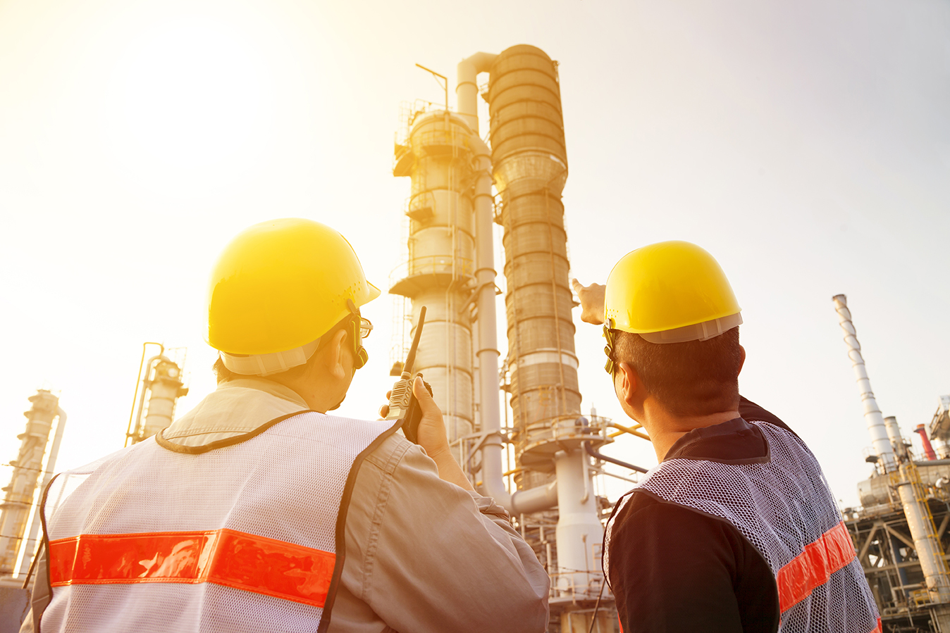refinery workers discussion and pointing for inspection